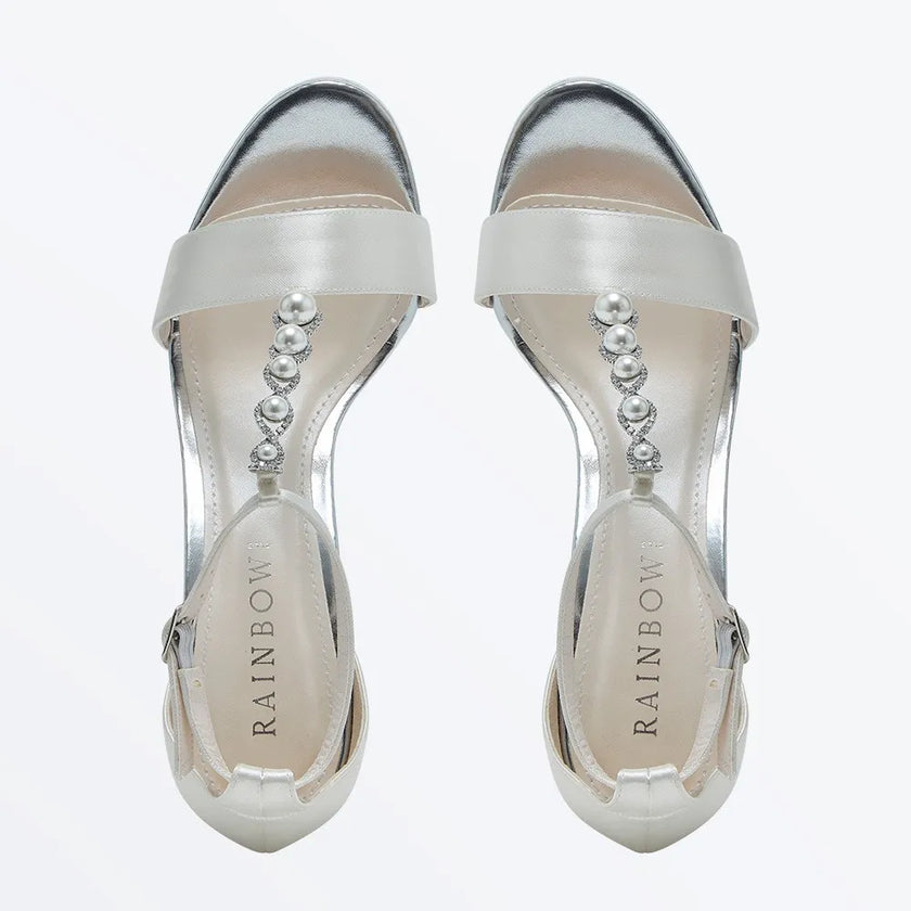 Sandalias de novia Lorelei en satén color marfil o ivory, con plataforma de 1,5 cm, tacón de bloque de 10 cm, decoradas con perlas y cristales swarovskipara un look elegante y sofisticado.